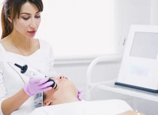 Co zrobić, gdy tradycyjna mezoterapia nie przynosi efektów? Lekarka wykonuje bezigłowy zabieg na twarzy pacjentki aparatem kosmetologicznym.