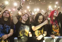 Jak sprawdzić skład i historię zespołu przed koncertem Tłum fanów pod sceną nagrywa koncert smartfonami i unosi ręce.